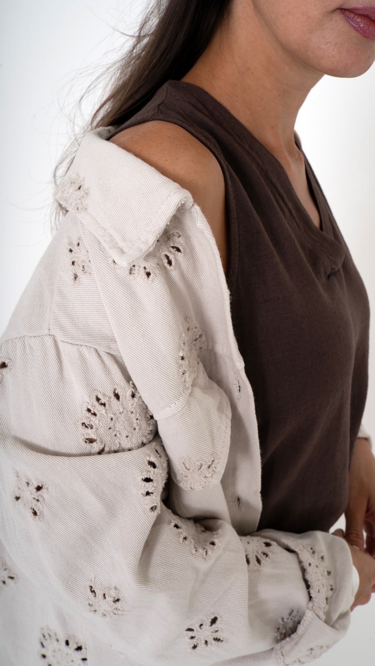 Detailansicht Anschnitt feminine Damenmode für den Sommer: Weite Denim Jacke mit floraler Lochstickerei in beige. Dazu ein braunes Top mit V-Ausschnitt