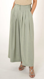 Detail Bild Fokus auf einer eleganten  weiten Damenhose mit Bundfalten und  Taschen. In der Farbe soft may green